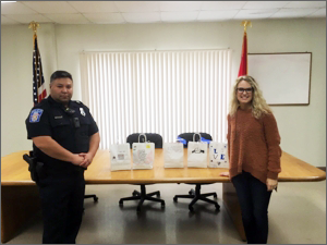 Photo of teacher, Lacey Lampley, and Chapel Hill Police receiving goodie bags from SMAK (Smart Minds Awesome Kids)